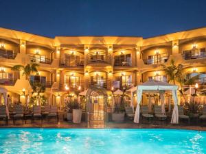 a hotel with a swimming pool at night at Pacific Terrace Hotel in San Diego