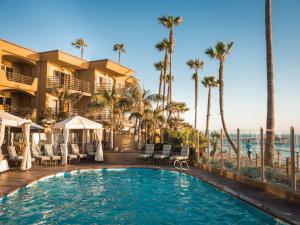a pool at a resort with palm trees at Pacific Terrace Hotel in San Diego
