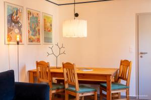 uma sala de jantar com uma mesa de madeira e cadeiras em FEWO in Weimar mit Garten am Schwanseebad em Weimar