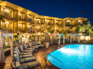 a hotel with a swimming pool in front of a building at Pacific Terrace Hotel in San Diego