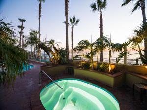 a hot tub with palm trees and the beach at Pacific Terrace Hotel in San Diego