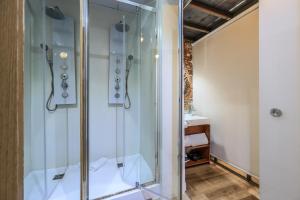 La salle de bains est pourvue d'une douche avec une porte en verre. dans l'établissement Apartamento centrico y comodo Preciados, à Madrid
