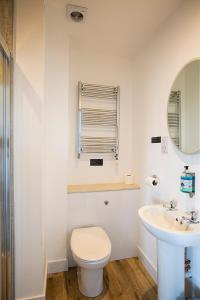 a white bathroom with a toilet and a sink at Poseidon Inn in Lossiemouth
