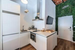 a kitchen with white cabinets and a green wall at Apartamento centrico y comodo Preciados in Madrid