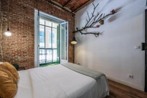 a bedroom with a bed and a brick wall at Apartamento centrico y comodo Preciados in Madrid