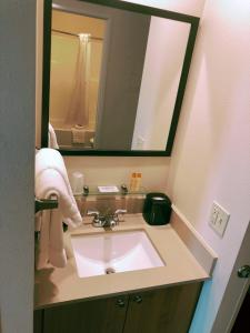 a bathroom with a sink and a large mirror at Aptel Studio Hotel in Anchorage