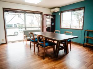 a dining room with a wooden table and chairs at シテコベハウス in Yokosuka