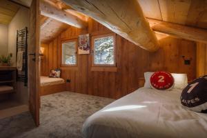 a bedroom with a bed in a wooden cabin at Chalet Happyview - OVO Network in Le Grand-Bornand +31 photos