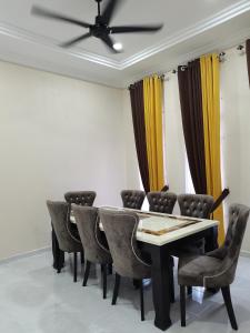 a dining room with a table and chairs at FIYA ViLA HOMESTAY in Ketereh