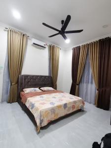 a bedroom with a bed and a ceiling fan at FIYA ViLA HOMESTAY in Ketereh
