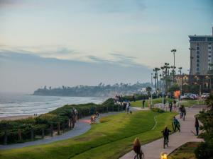a group of people walking and biking on a sidewalk near the beach at Pacific Terrace Hotel in San Diego