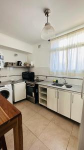 une grande cuisine avec des placards blancs et un évier dans l'établissement Bragado Siempre 247, à Bragado