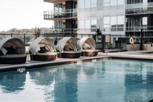 a hotel swimming pool with domed chairs next to a building at Level Seattle Downtown South Lake Union in Seattle