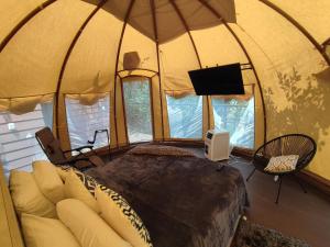 een slaapkamer in een koepeltent met een bed en een tv bij Glamping romantico en Vista Hermosa disfruta de la naturaleza en un ambiente privado y acogedor in La Mesa
