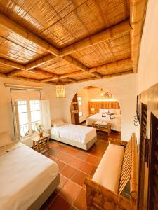 a bedroom with two beds and a large wooden ceiling at Casa Gabriel Rivera in Rivera