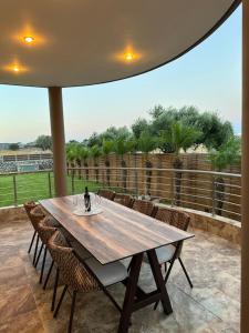 drewniany stół i krzesła na patio w obiekcie Costa Costa Villa - Luxury villa w Kolymbii