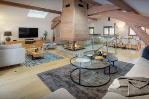 a living room with a fireplace and a table at Chalet Riparian - OVO Network in La Clusaz