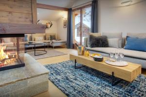 a living room with a couch and a fireplace at Chalet Riparian - OVO Network in La Clusaz