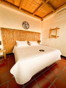 a bedroom with a large white bed with a clock on the wall at Casa Gabriel Rivera in Rivera