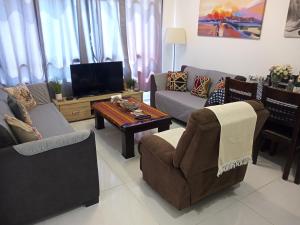 a living room with couches and a tv and a table at Yafe Nof 35 in Ashqelon