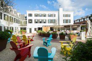 une terrasse avec des chaises colorées devant un bâtiment dans l'établissement Delamar Southport, à Southport