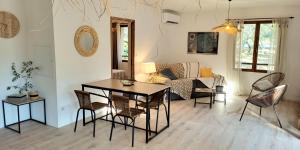 a living room with a table and chairs and a couch at Les jardins de Foata in Barbaggio