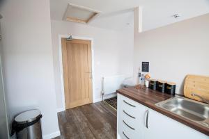 uma cozinha com um lavatório e uma bancada de madeira em Poseidon Inn em Lossiemouth
