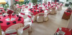 een rij tafels en stoelen met rode en witte decoraties bij Hotel Kintop in Udugama