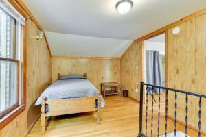 een slaapkamer met een bed in een kamer met houten wanden bij Point Breeze Vacation Rental, Walk to Lake Ontario in Waterport