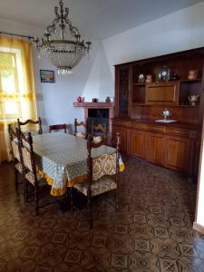 una sala da pranzo con tavolo, sedie e lampadario di BELLAVISTA - Appartamenti sul Lago di Scanno a Scanno
