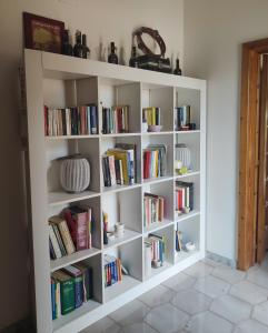 a white book shelf filled with books in a room at La Casa di Dario in Monacizzo
