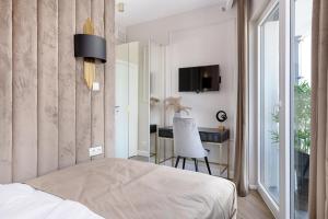 2-Bedroom DeLux Apartment with Private Sauna WWA24 في وارسو: غرفة نوم بسرير ومكتب وتلفزيون