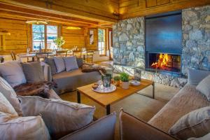 a living room with a couch and a fireplace at Chalet Sisar - OVO Network in La Clusaz