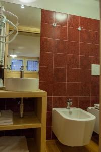 ein Bad mit einem Waschbecken und einem Spiegel in der Unterkunft Zwargji in Formazza