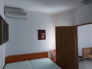 - une chambre avec un lit et une porte menant à une pièce dans l'établissement Apartman 5-6, à Stara Novalja
