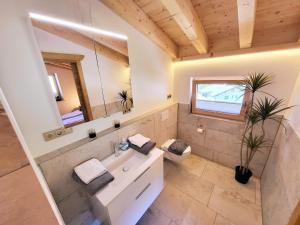 a bathroom with a sink and a mirror at Schickster Sky Lodge und Chalet Rossi in Leutasch +128 photos