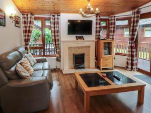 a living room with a couch and a fireplace at Langdale Lodge 15 in Windermere