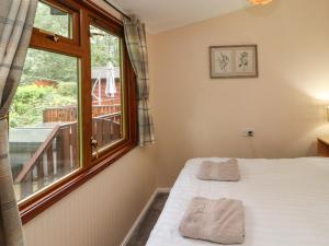 sypialnia z łóżkiem i oknem w obiekcie Langdale Lodge 15 w mieście Windermere