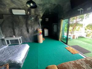 a room with a bed and a green carpet at สวนป่าภูนับดาว รีสอร์ท เขาค้อ in Ban Khao Ya Nua