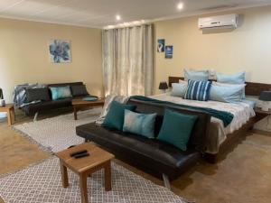 a living room with a large bed and a couch at R A GUEST HOUSE PEMBA in Pemba