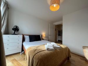 a bedroom with a bed with towels on it at Victoria suite in London