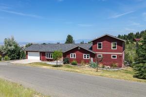 a red house on the side of a road at Mountain-View Rental with Hot Tub - 9 Mi to Helena! in Clancy