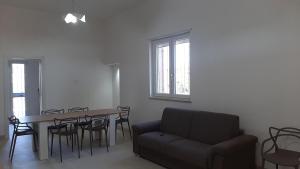 uma sala de estar com um sofá, uma mesa e cadeiras em VILLA LISA em Francavilla Fontana
