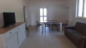 uma sala de estar com uma mesa de jantar e uma televisão em VILLA LISA em Francavilla Fontana