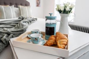 bandeja con cruasanes y tazas de café en una mesa en The Laurel Cottage, en Doncaster