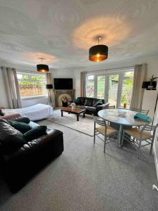 a living room with a couch and a table at Spindrift, Spacious bungalow near beach in Hamworthy