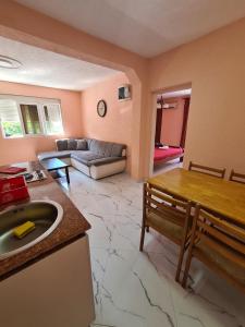 a kitchen and living room with a table and a couch at Apartments Bulatović in Bar