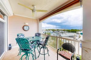 a balcony with a table and chairs and a clock at Tarpon Watch in Key West