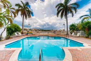 a swimming pool with palm trees in a resort at Tarpon Watch in Key West