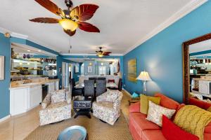 Tarpon Watch في كي ويست: غرفة معيشة مع أريكة حمراء وكراسي